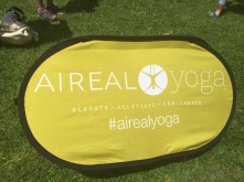 Excellent branding and portable sign staked into the grass #airealyoga